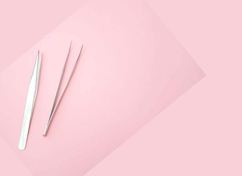 Silver Tweezers on Pink Background at Lash Layer Boutique